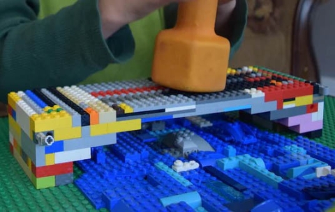 Lego bridge being tested with a weight.